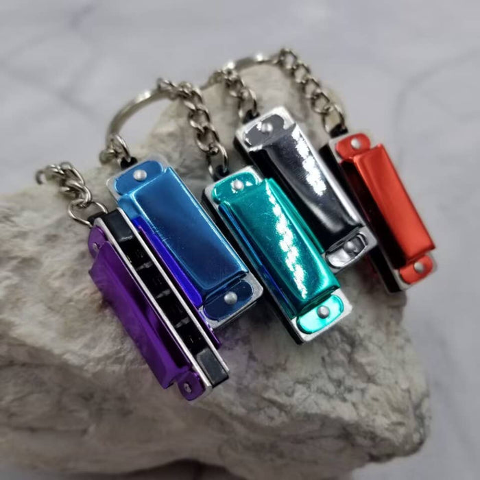 Set of colorful miniature harmonica keychains on a stone surface