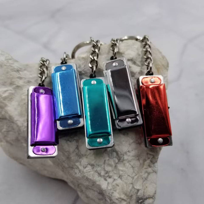 Five colorful harmonica keychains on a rock