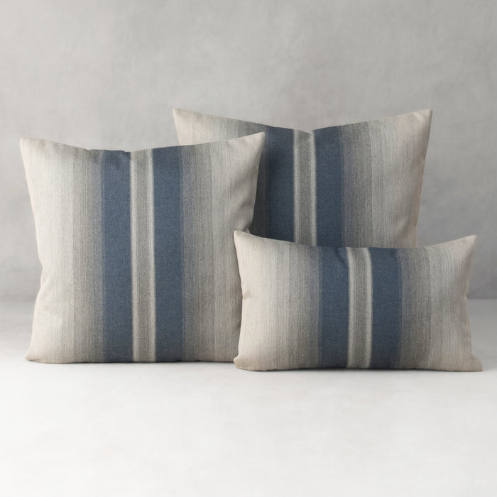 Three striped pillows on a neutral background