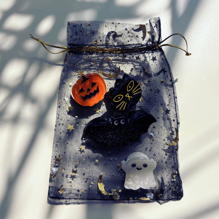 Halloween-themed decorative bag with pumpkin, witch hat, and ghost on a white background