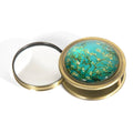 Compact magnifying glass with floral design on a white background